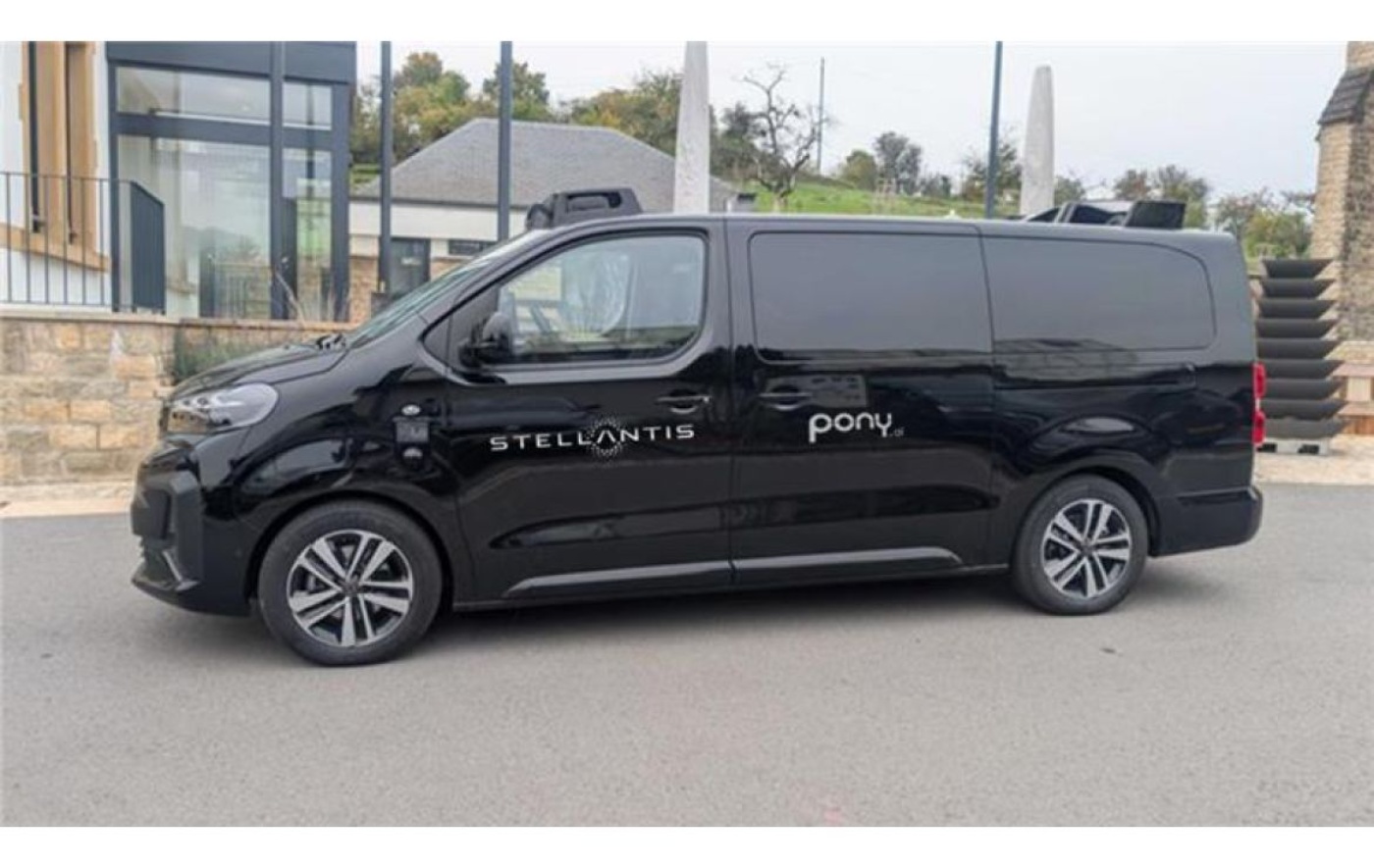 Ein schwarzer autonomer Van mit Stellantis- und Pony.ai-Logos steht am Straßenrand.