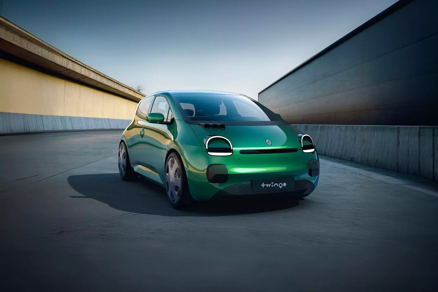 Green Renault Twingo E-Tech compact car with round headlights on an empty road between concrete walls.