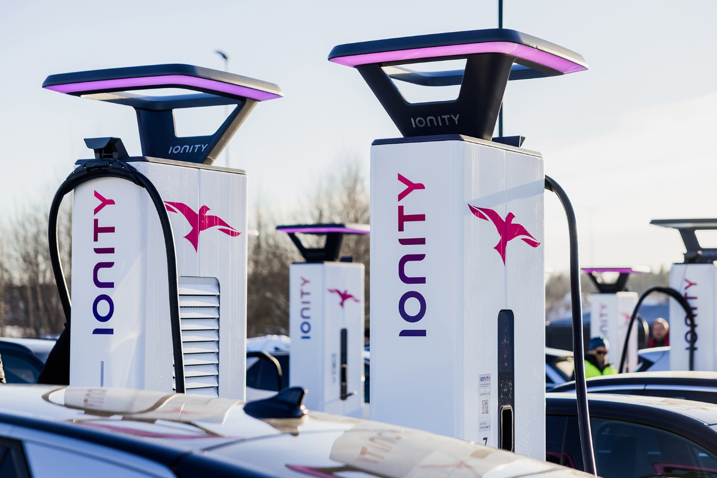 Mehrere Ionity-Ladestationen werden draußen von E-Autos genutzt.