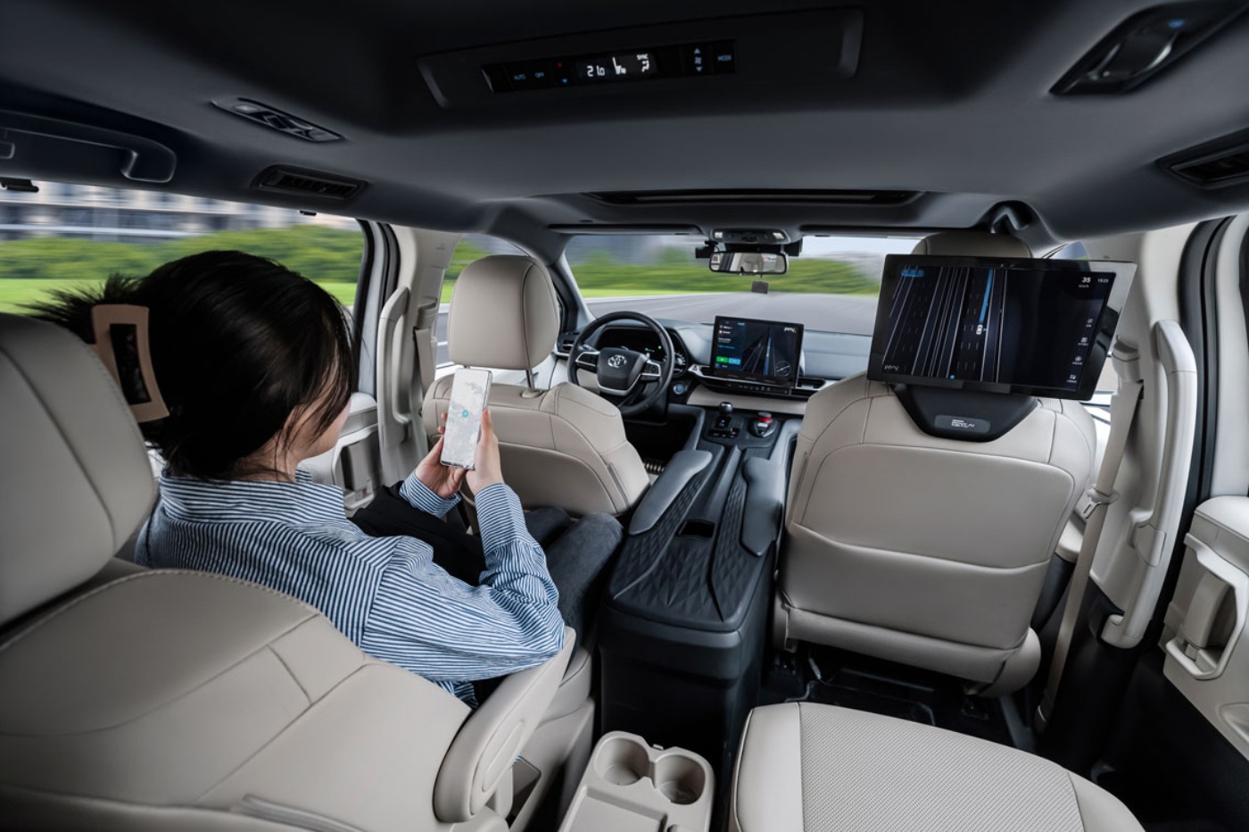 Fahrgast nutzt Smartphone im autonomen Fahrzeug.