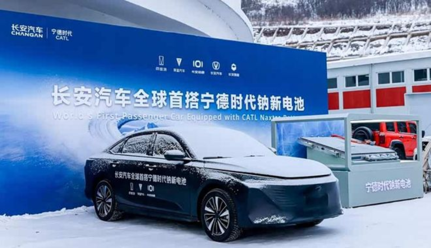 Electric car in snow at booth with Chinese event banner.