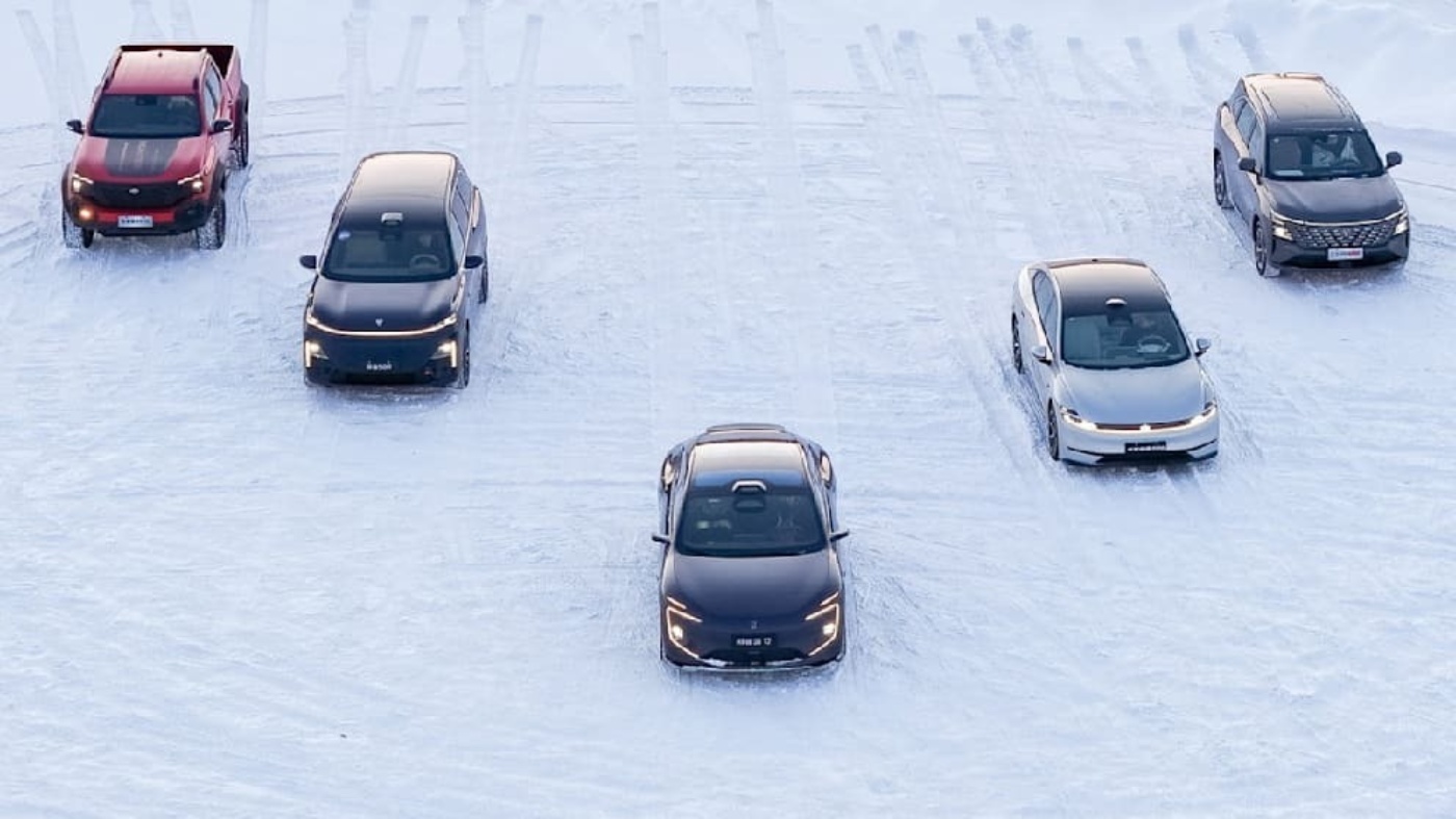 Fünf Autos fahren in Formation auf einer verschneiten Teststrecke