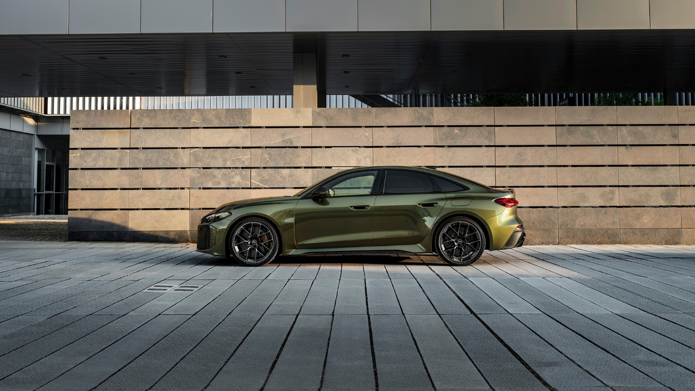 Grüne Audi-Limousine steht vor einem modernen Betongebäude.