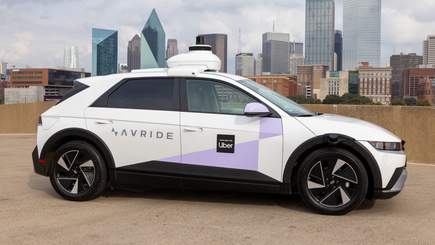 Autonomes AVride-Fahrzeug für Uber vor einer Stadtsilhouette.
