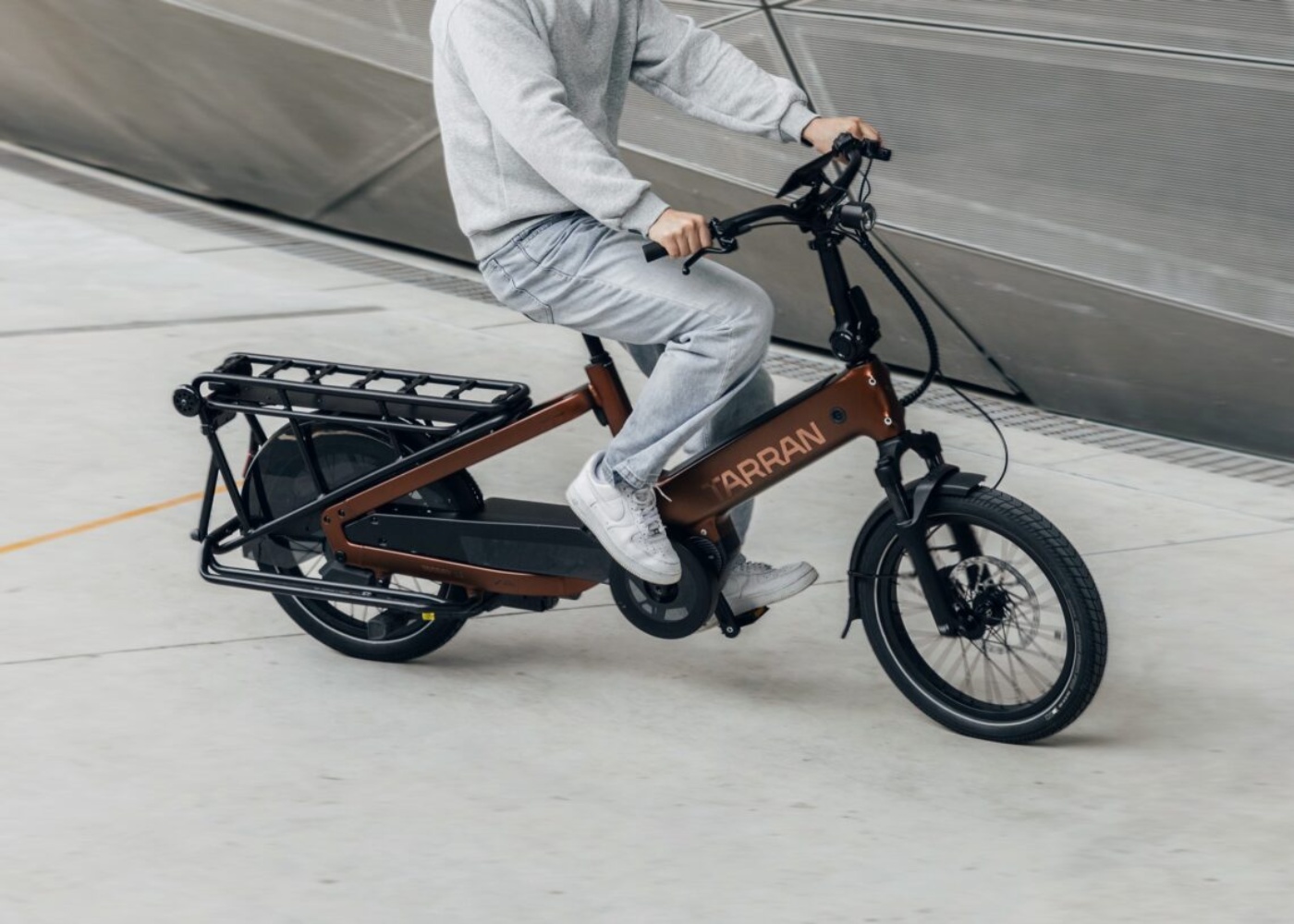Person fährt ein Tarran Lasten-E-Bike in urbaner Umgebung.