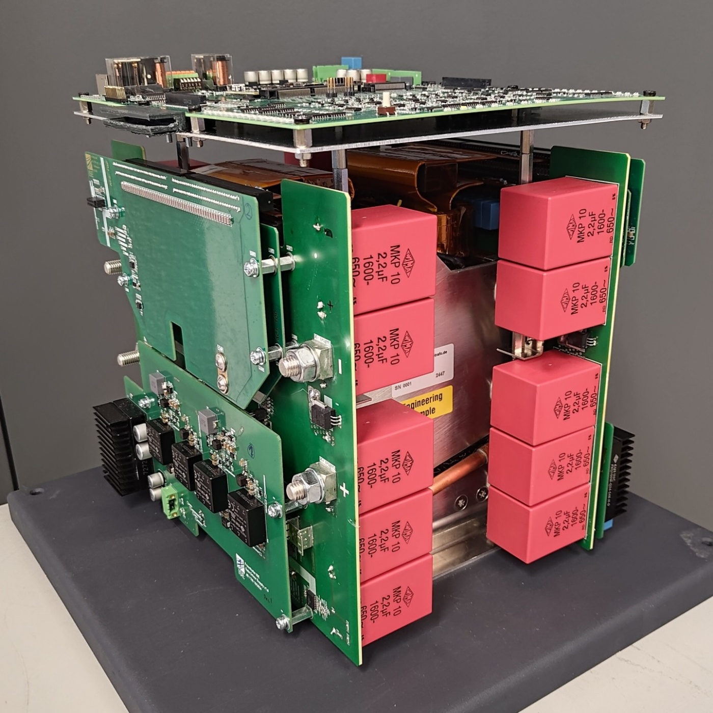 Modular battery storage system with green frame and red battery units on display.