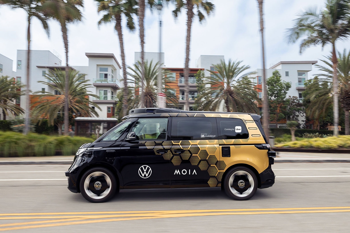 MOIA electric shuttle driving on a street with palm trees