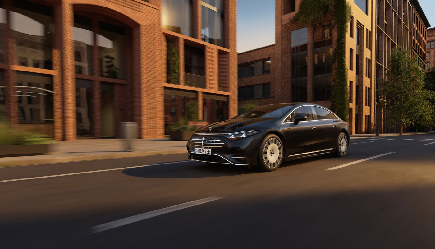 Schwarze Mercedes-Benz Limousine fährt durch eine moderne Stadtstraße