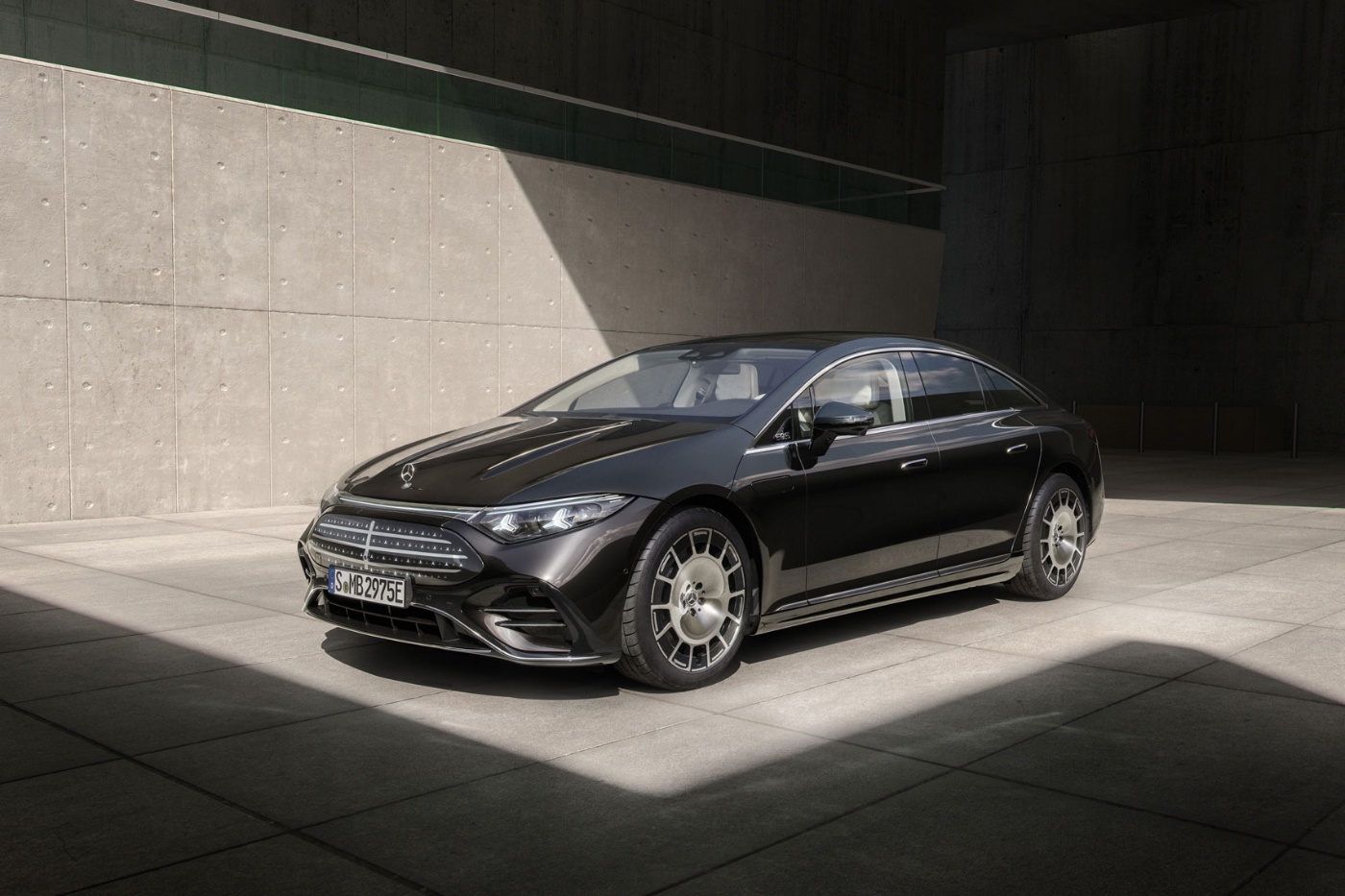 Black Mercedes-Benz parked in sunlight against a concrete wall