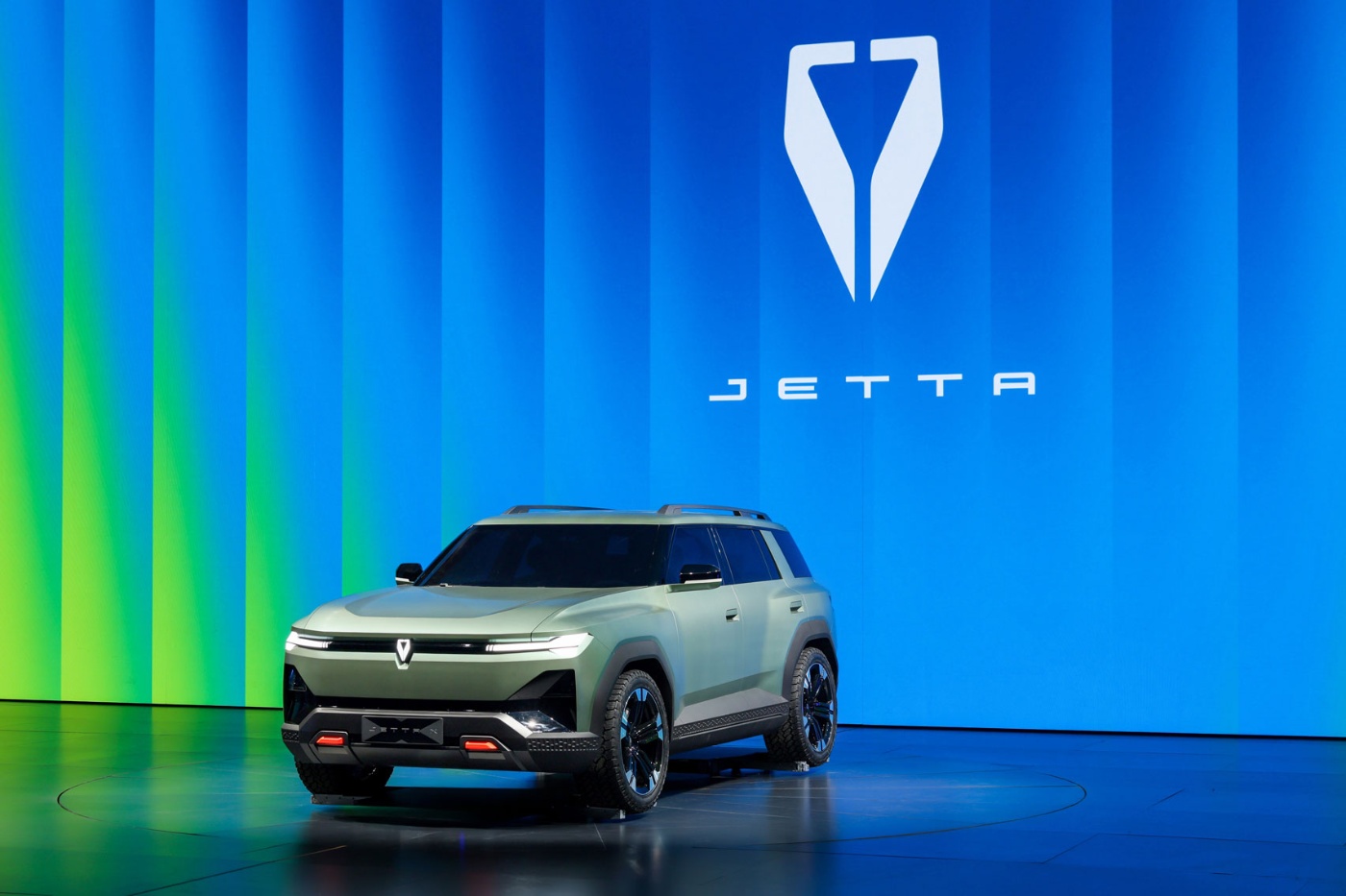 Jetta SUV auf einer Bühne vor blauem Hintergrund mit Logo.