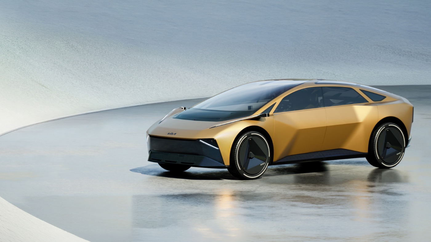Golden futuristic electric car on a stage in a modern showroom.