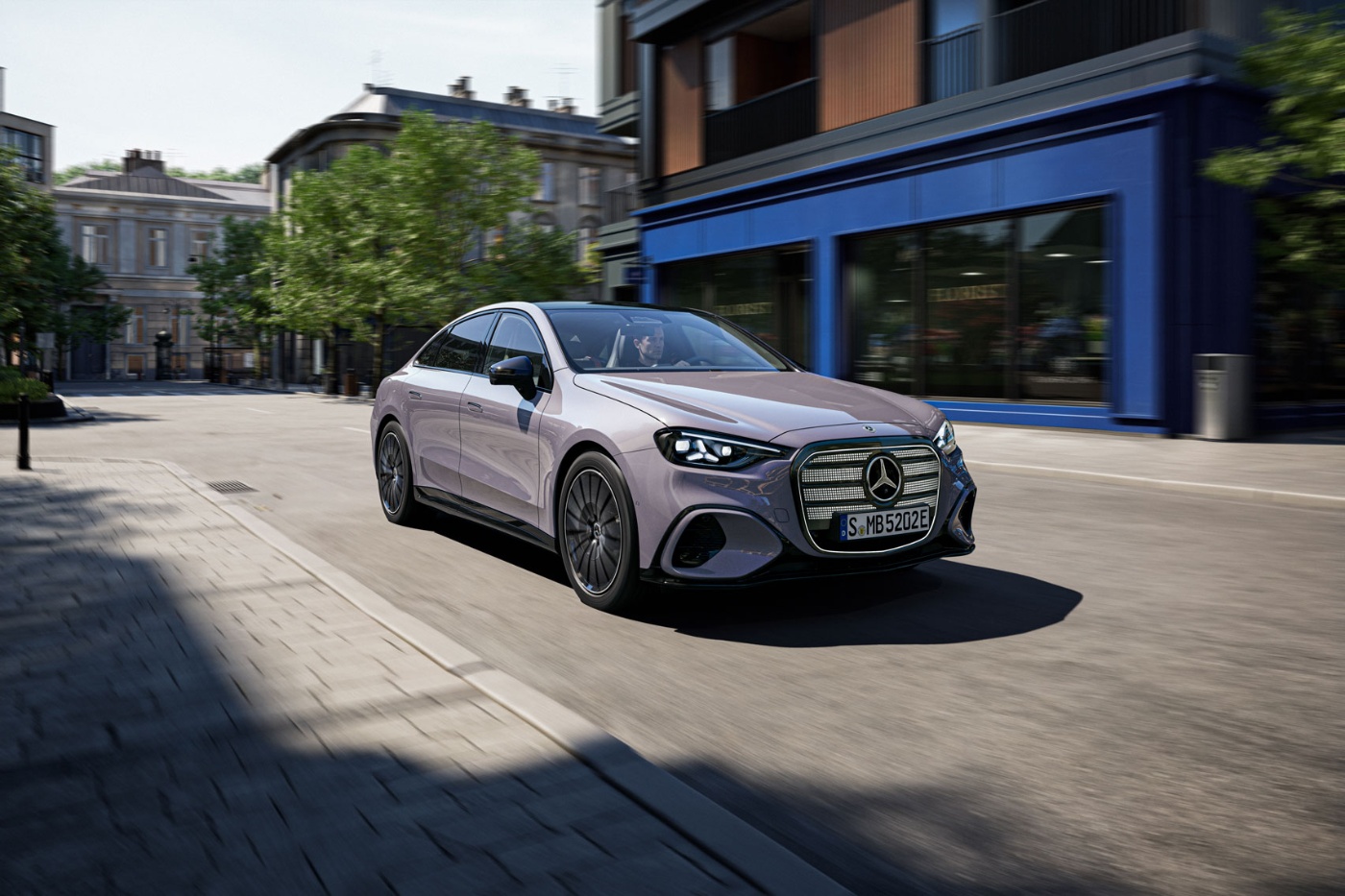 Gray Mercedes-Benz sedan driving through a city street.