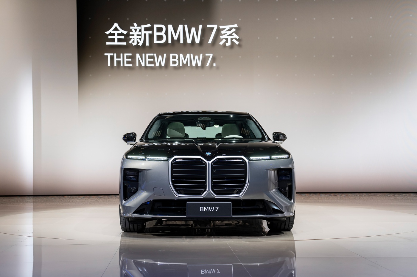 Frontansicht des neuen BMW 7 auf einer Bühne mit Logo-Wand im Hintergrund.