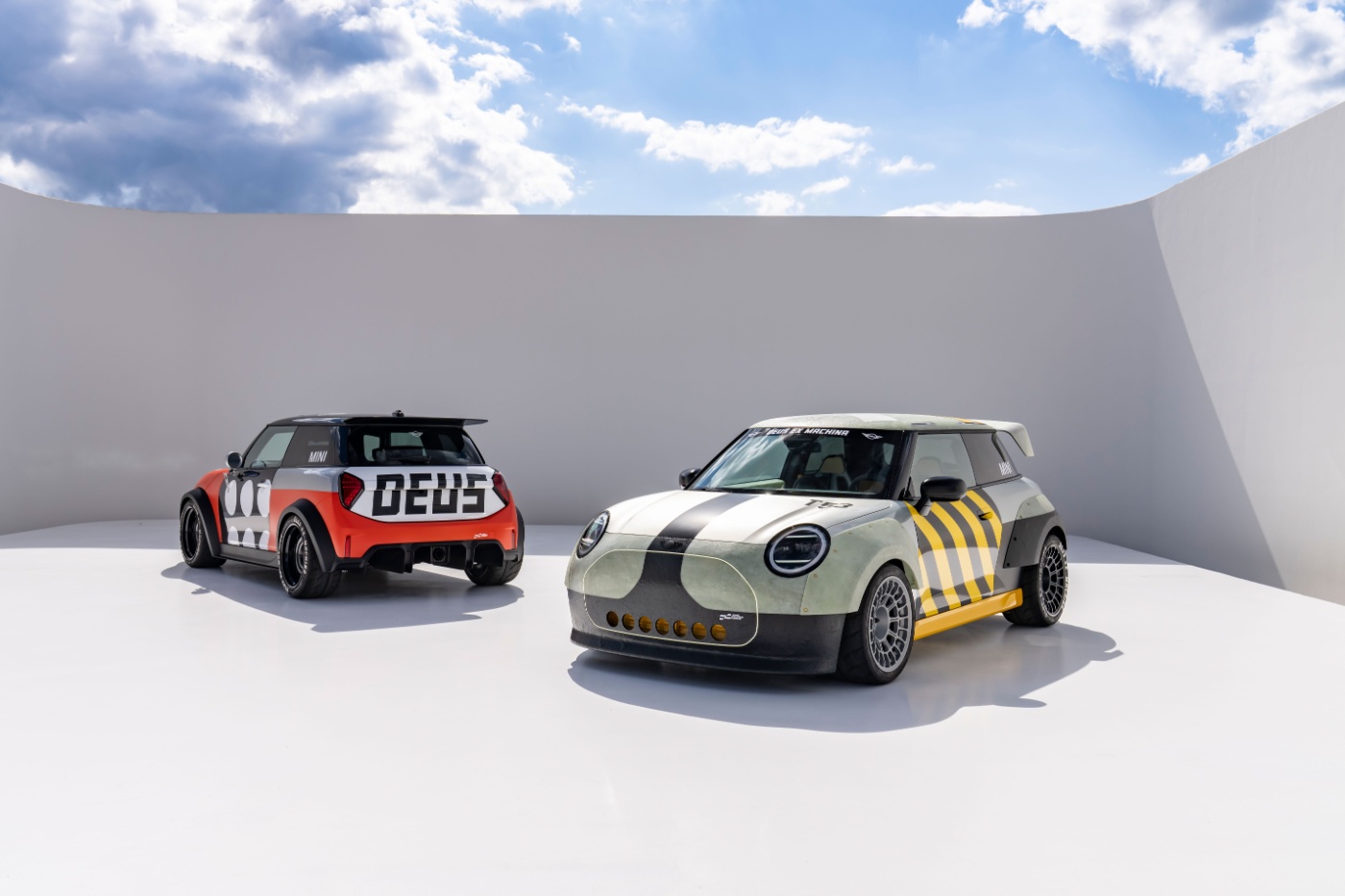 Two customized Mini cars parked in a minimalist outdoor setting.