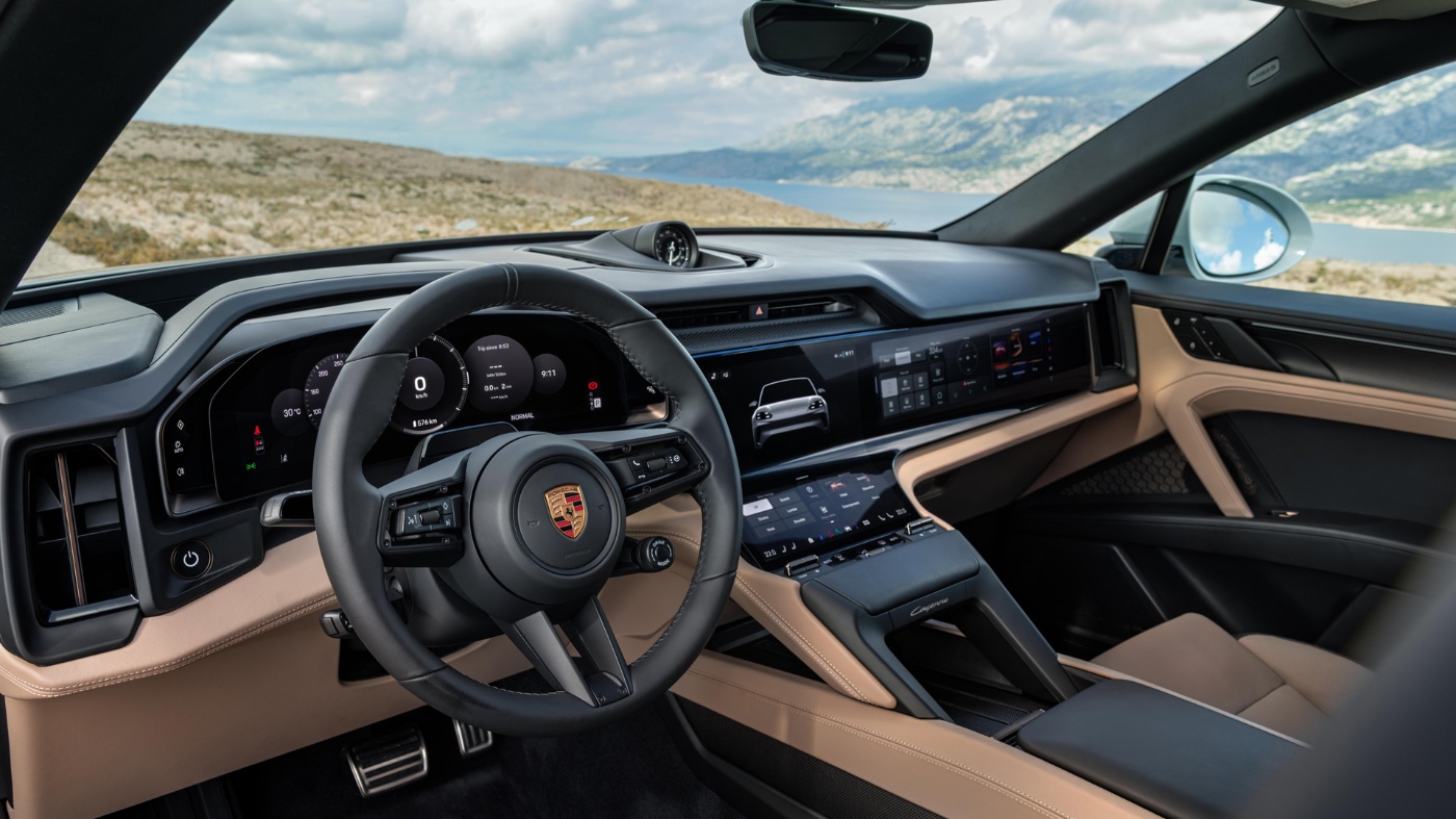 Interior of a Porsche with digital displays and steering wheel.