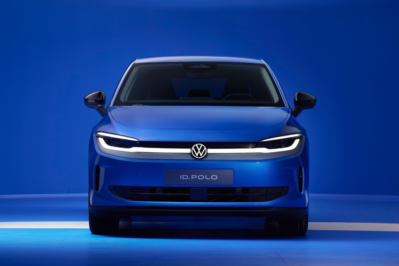 Front view of a blue Volkswagen ID.Polo in a blue studio.