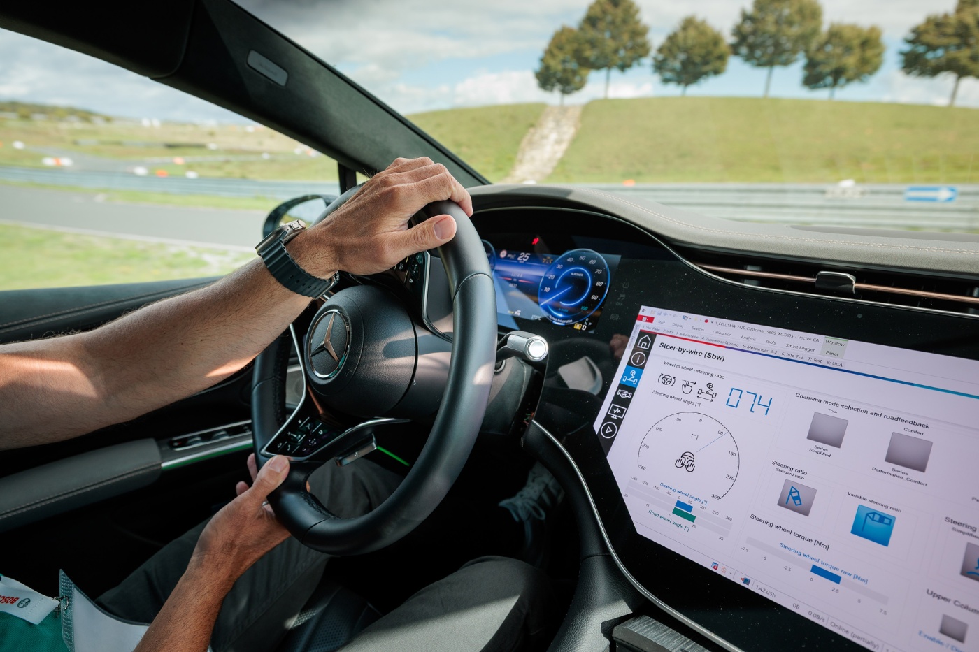 Fahrer hält Lenkrad mit digitalem Display und Touchscreen.