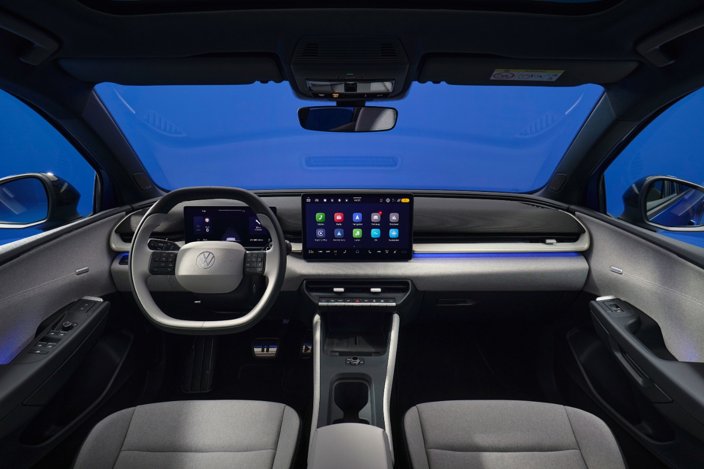 Modern car interior with steering wheel and central touchscreen display.