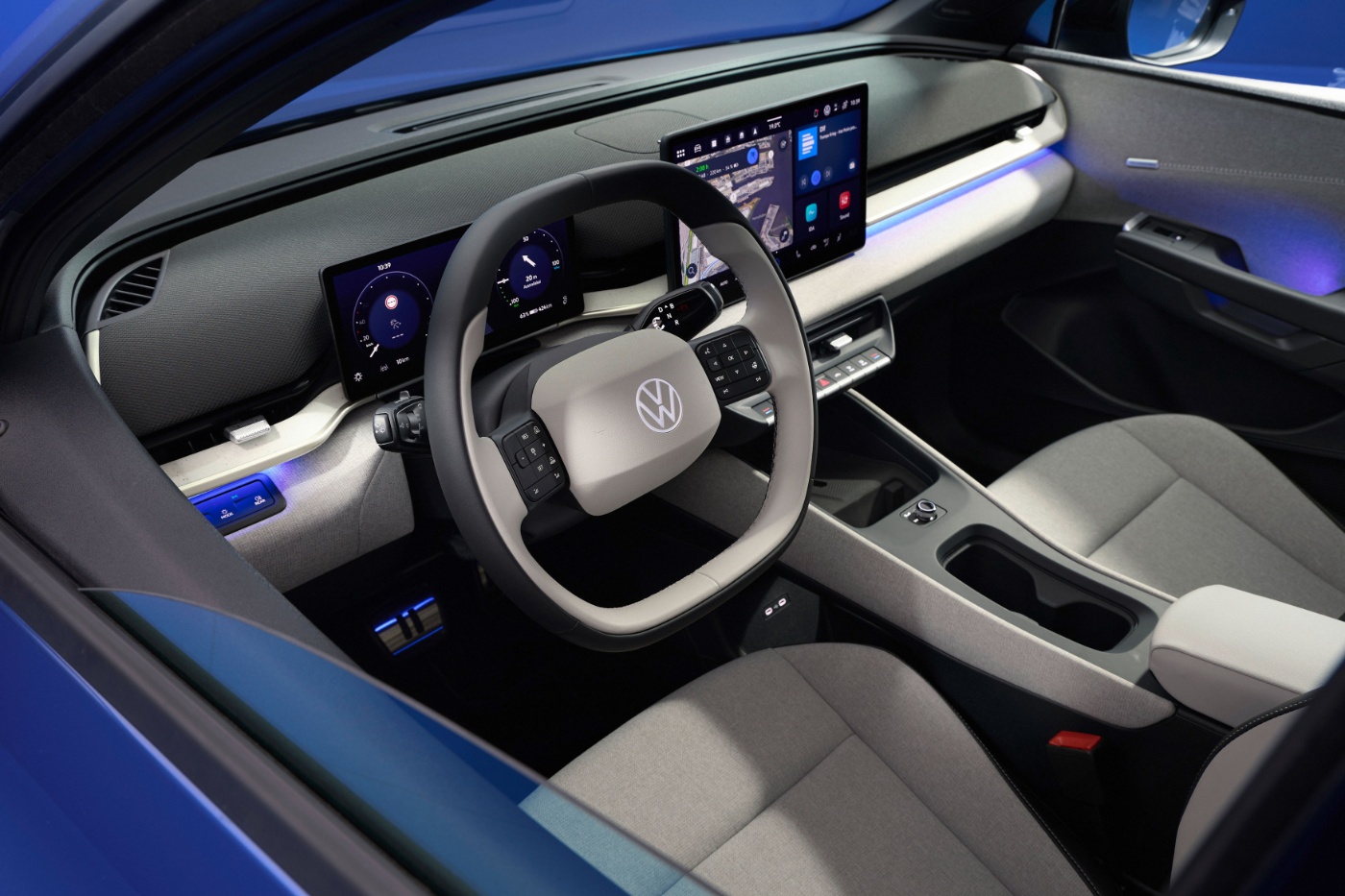 Car interior with steering wheel, digital display and center console.
