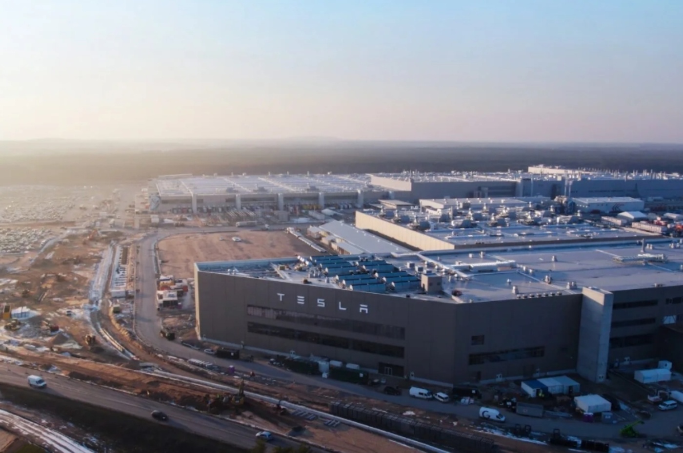 Luftaufnahme eines Tesla-Werks mit großen Produktionsgebäuden.