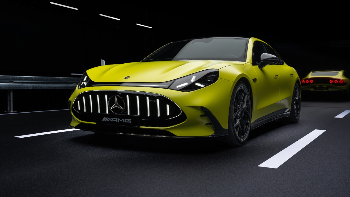 Yellow Mercedes-AMG sports car driving at night on a road.