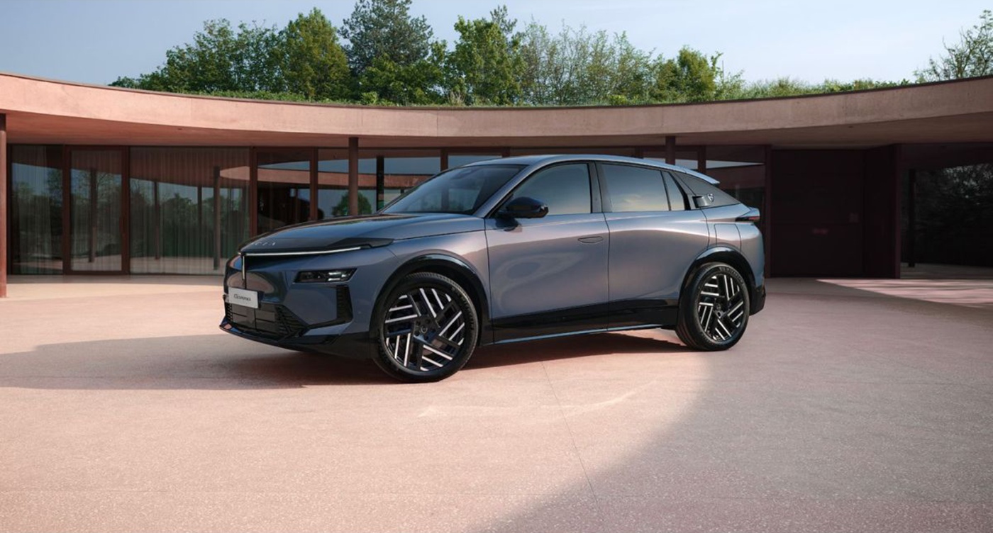 Grauer SUV steht vor einem modernen, runden Gebäude.