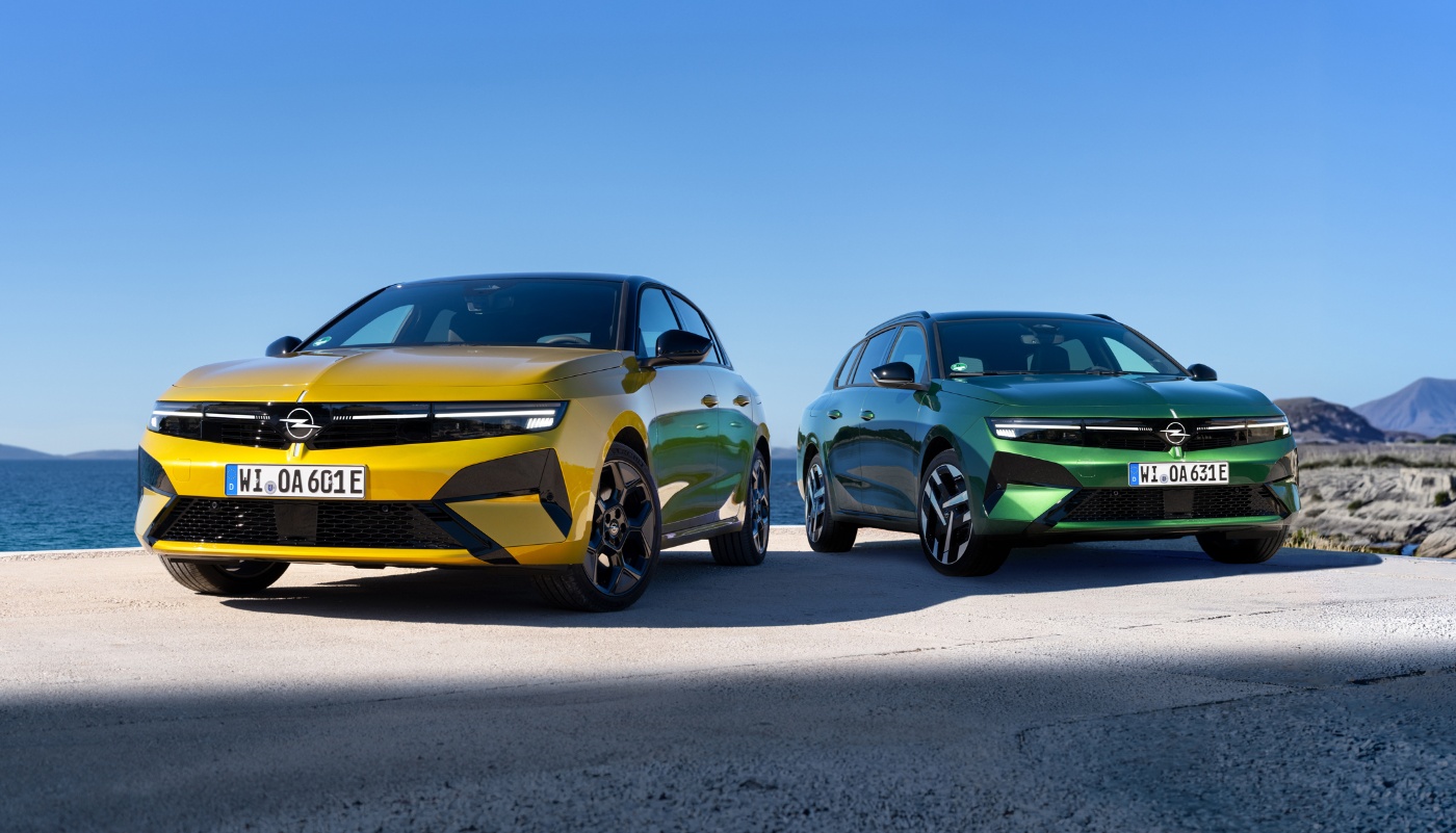 Gelber und grüner Opel stehen nebeneinander am Meer.