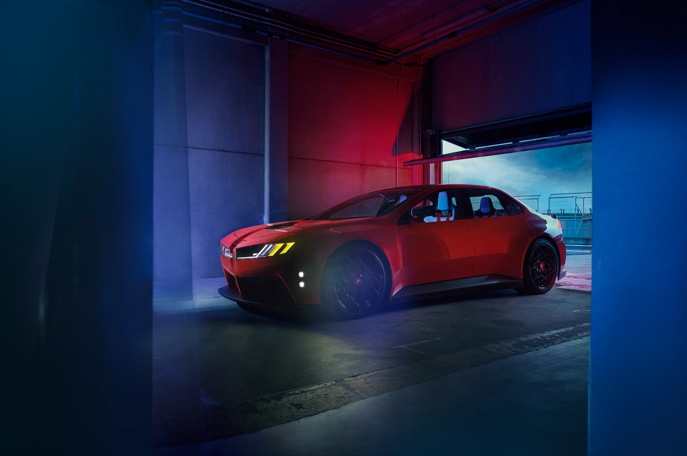 Red BMW parked in an illuminated indoor garage.