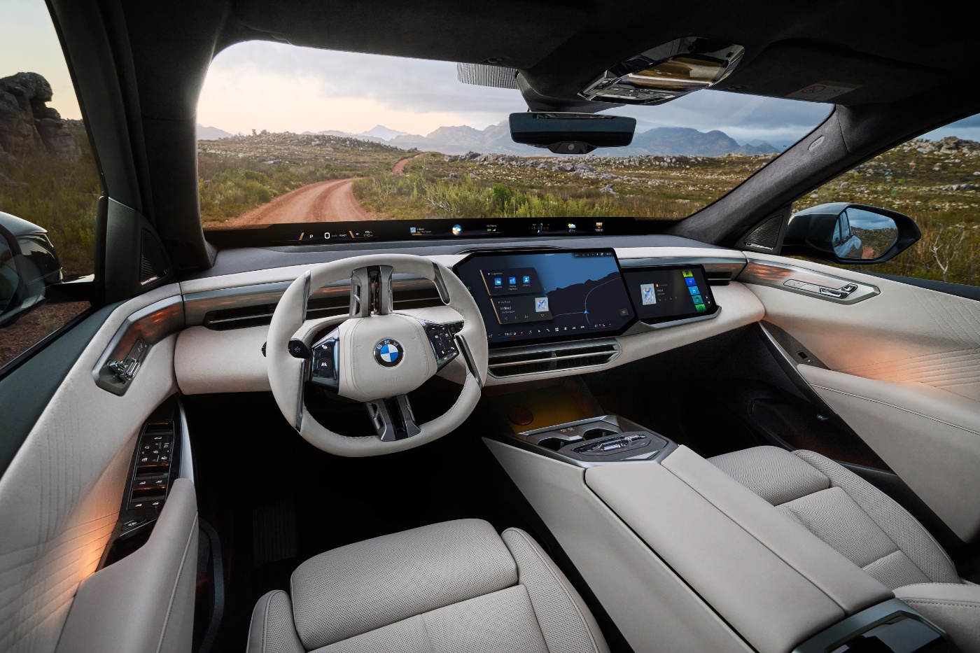 Blick vom Fahrersitz eines BMW mit digitalem Cockpit und Straße vor dem Fahrzeug.