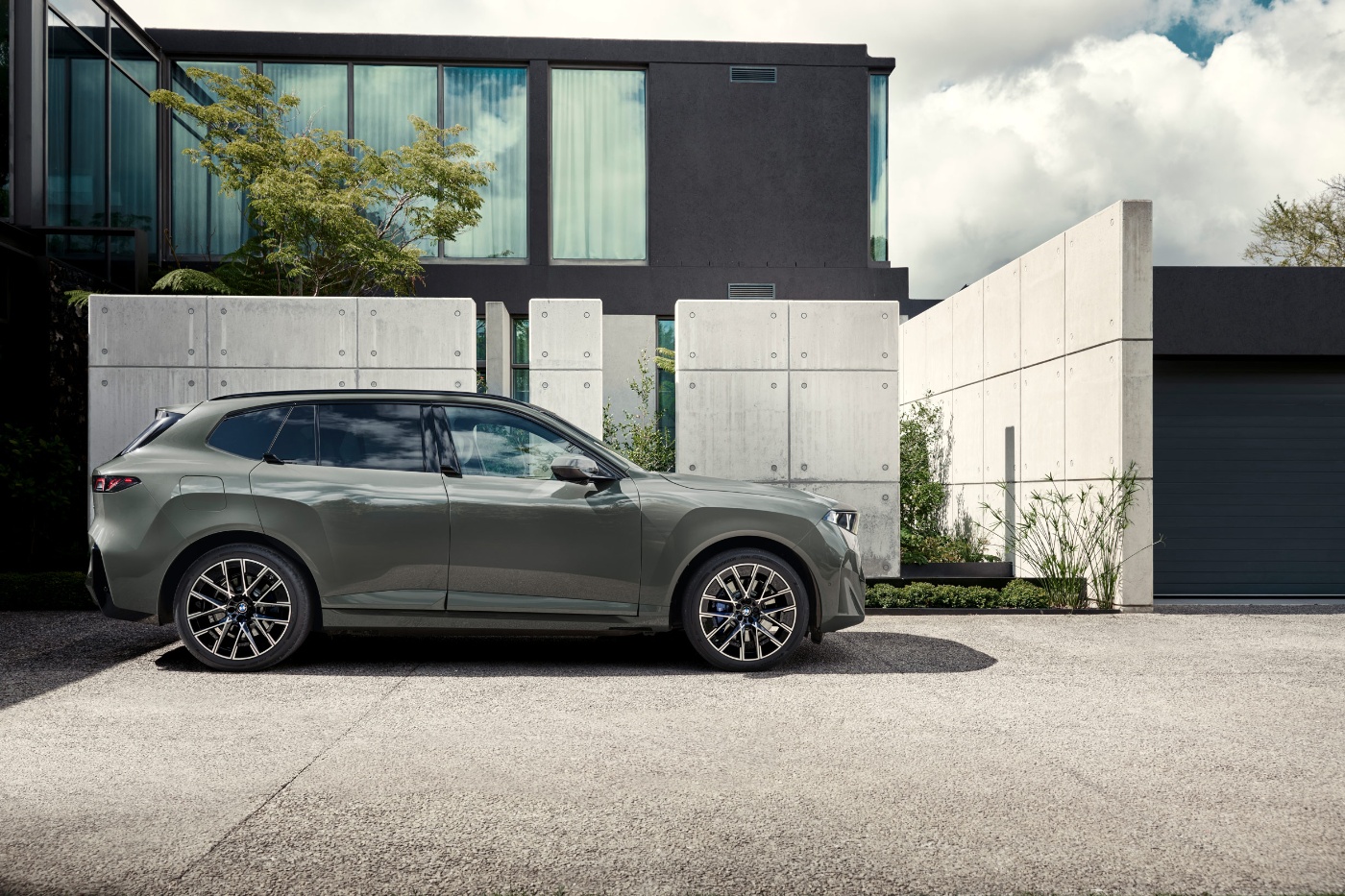 BMW SUV steht vor einem modernen Wohnhaus in der Seitenansicht.