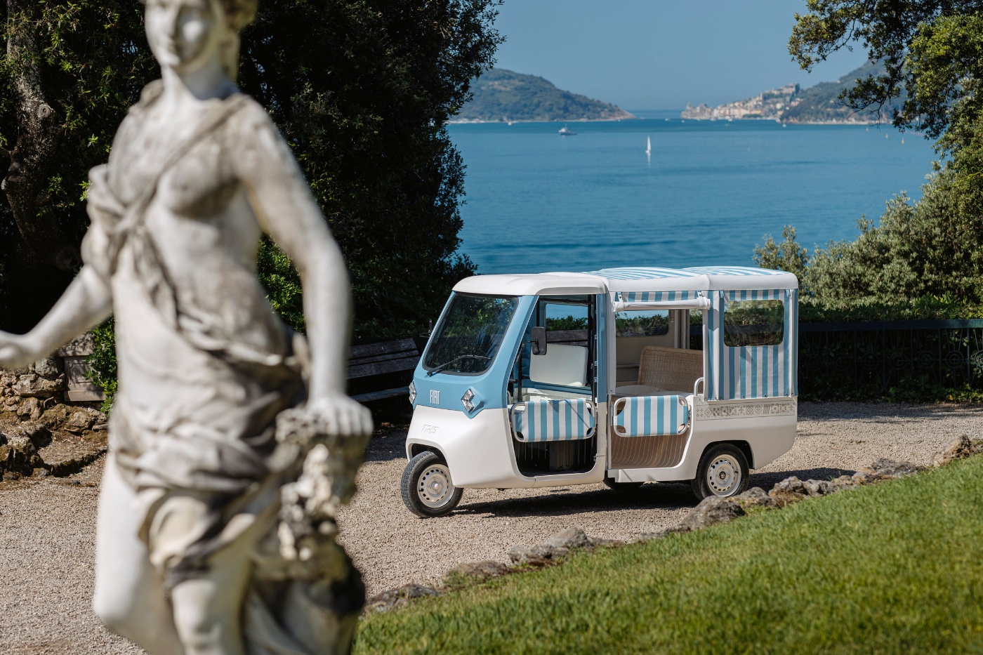 Kompaktes Fiat-Konzeptfahrzeug steht in einem Garten vor einem See.