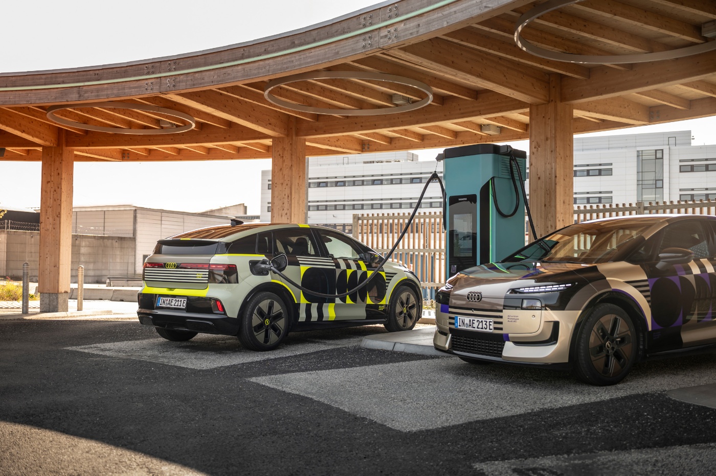 Audi prototype electric vehicle charging at a fast-charging station under a solar canopy.