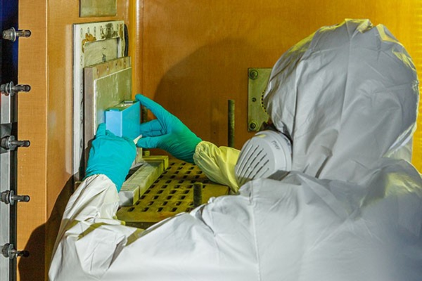 Person in Schutzkleidung arbeitet an einem Versuchsaufbau am Fraunhofer EMI.
