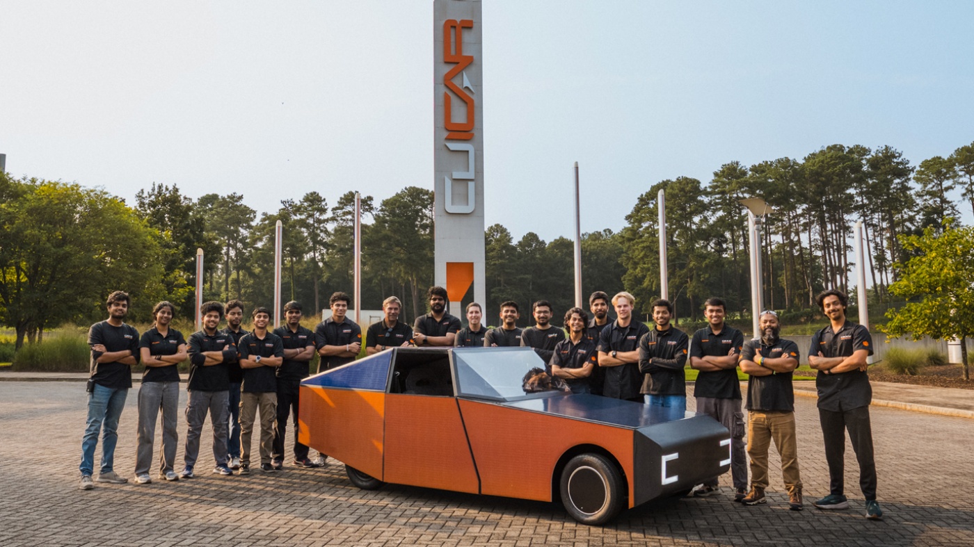 Clemson University team posing with an orange autonomous vehicle.