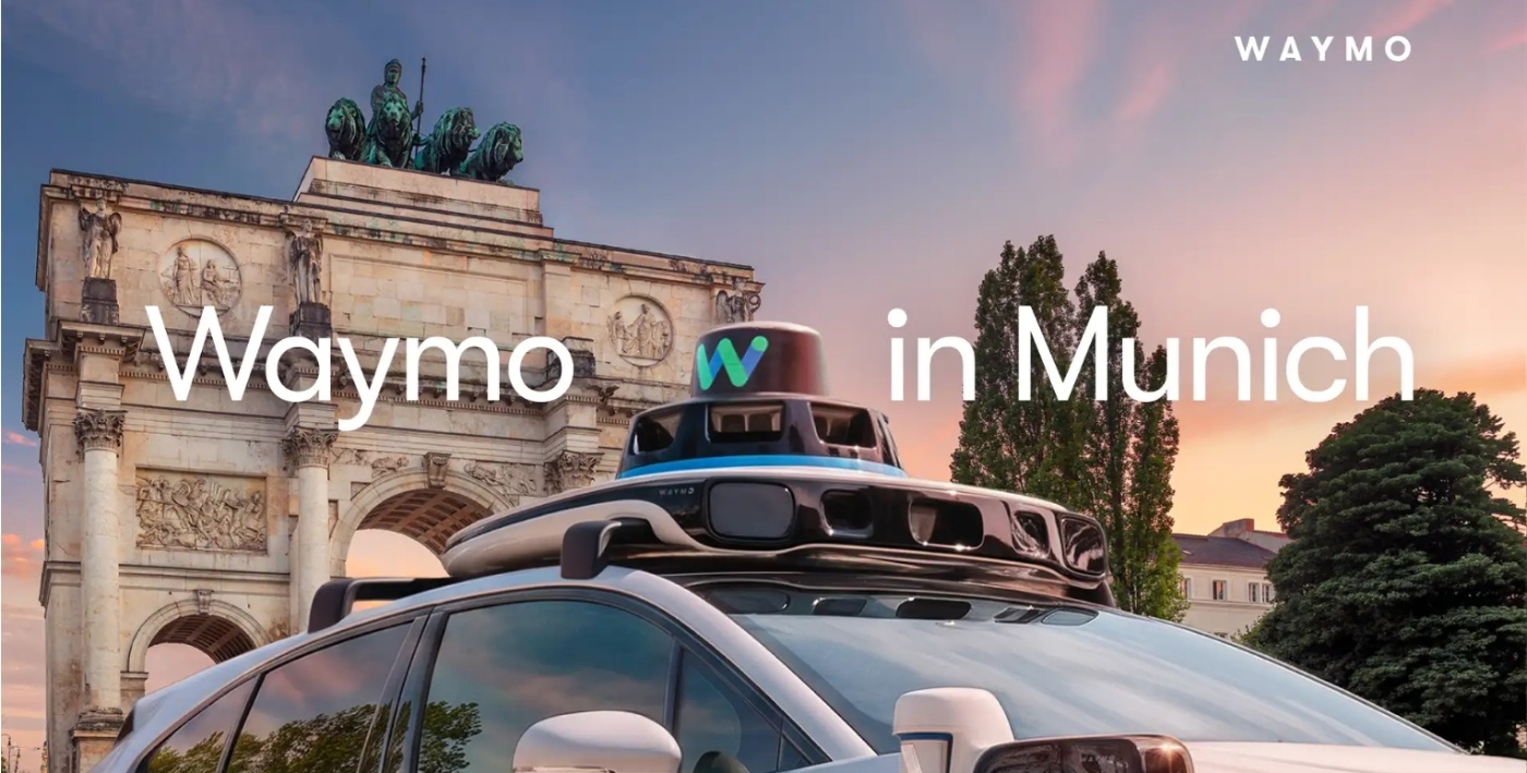 Autonomes Waymo Fahrzeug mit Dachsensoren vor einem Münchner Wahrzeichen.