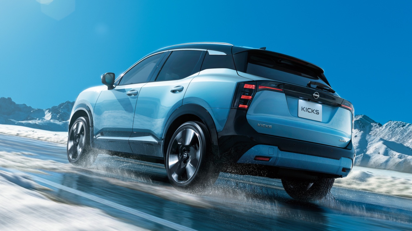 Weißer Nissan SUV fährt auf einer verschneiten Bergstraße.