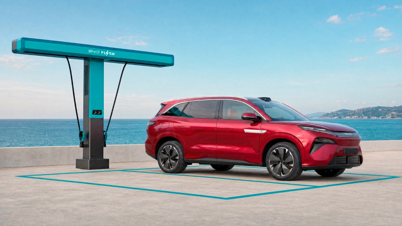 Roter BYD Elektro-SUV steht neben einer Ladestation am Meer.