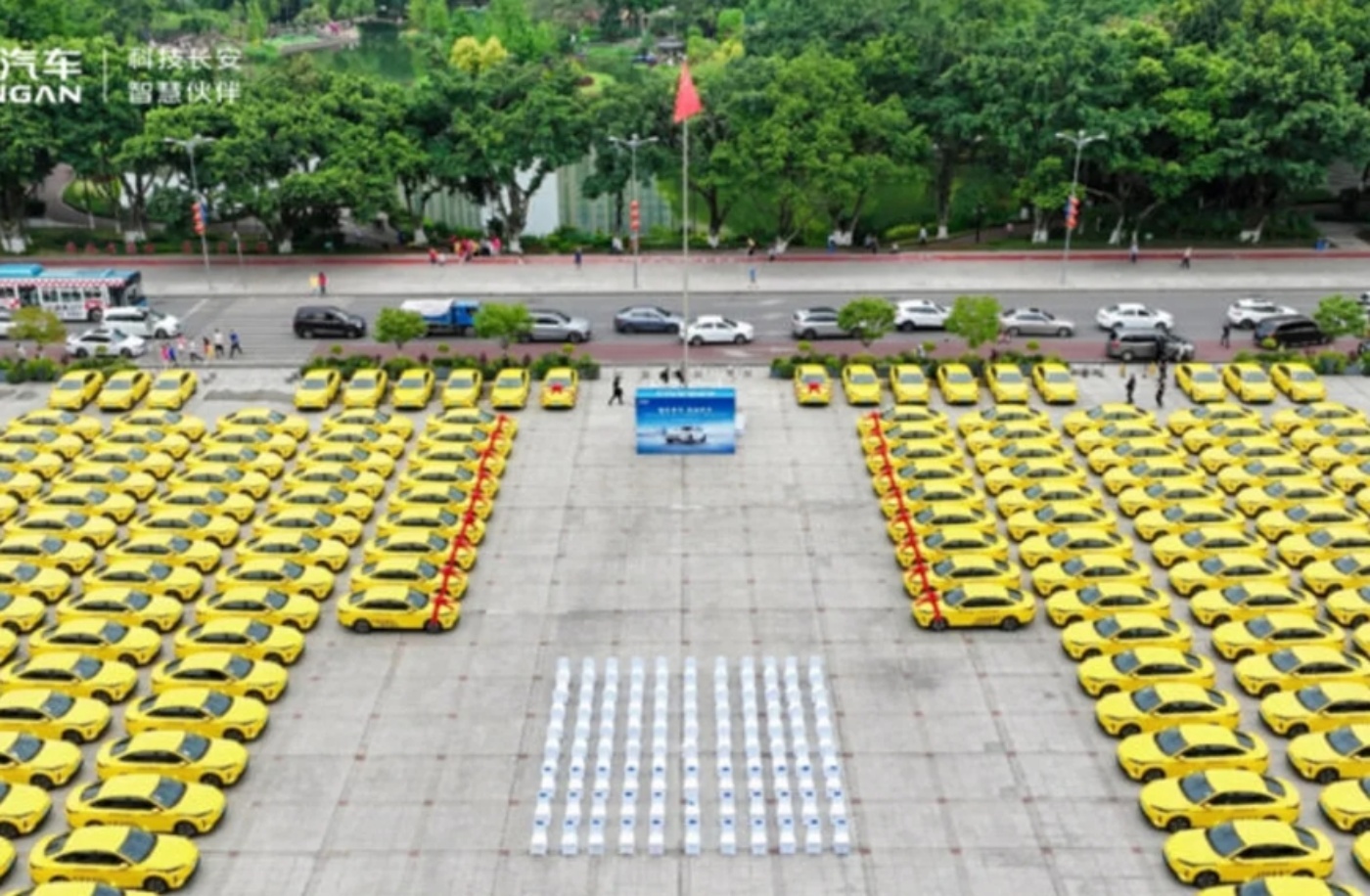 Rows of yellow Changan cars arranged in a large formation on an open square.