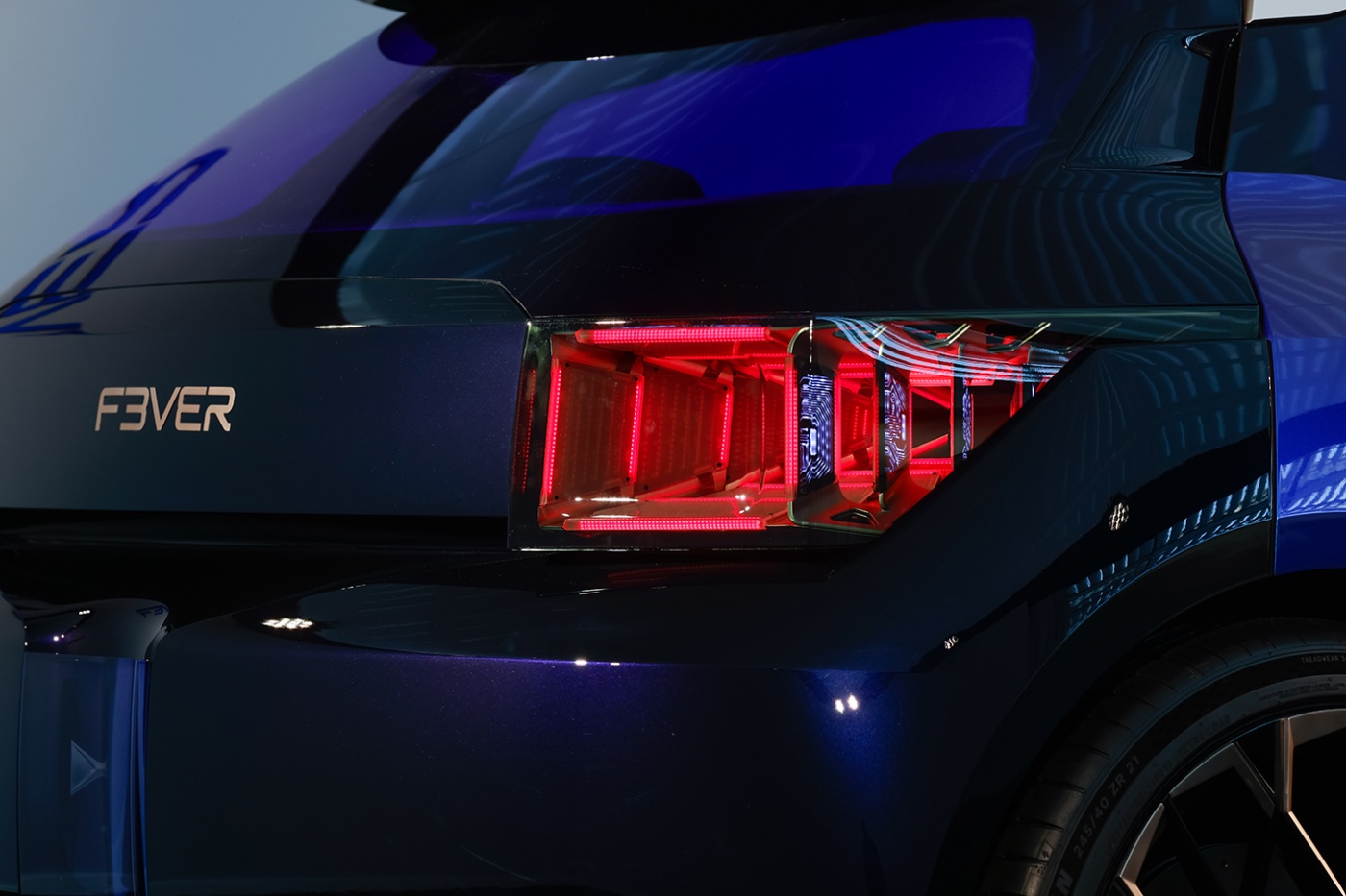 Nahaufnahme des Hecks eines dunkelblauen F3VER-Konzeptautos mit futuristischen roten LED-Rücklichtern.
