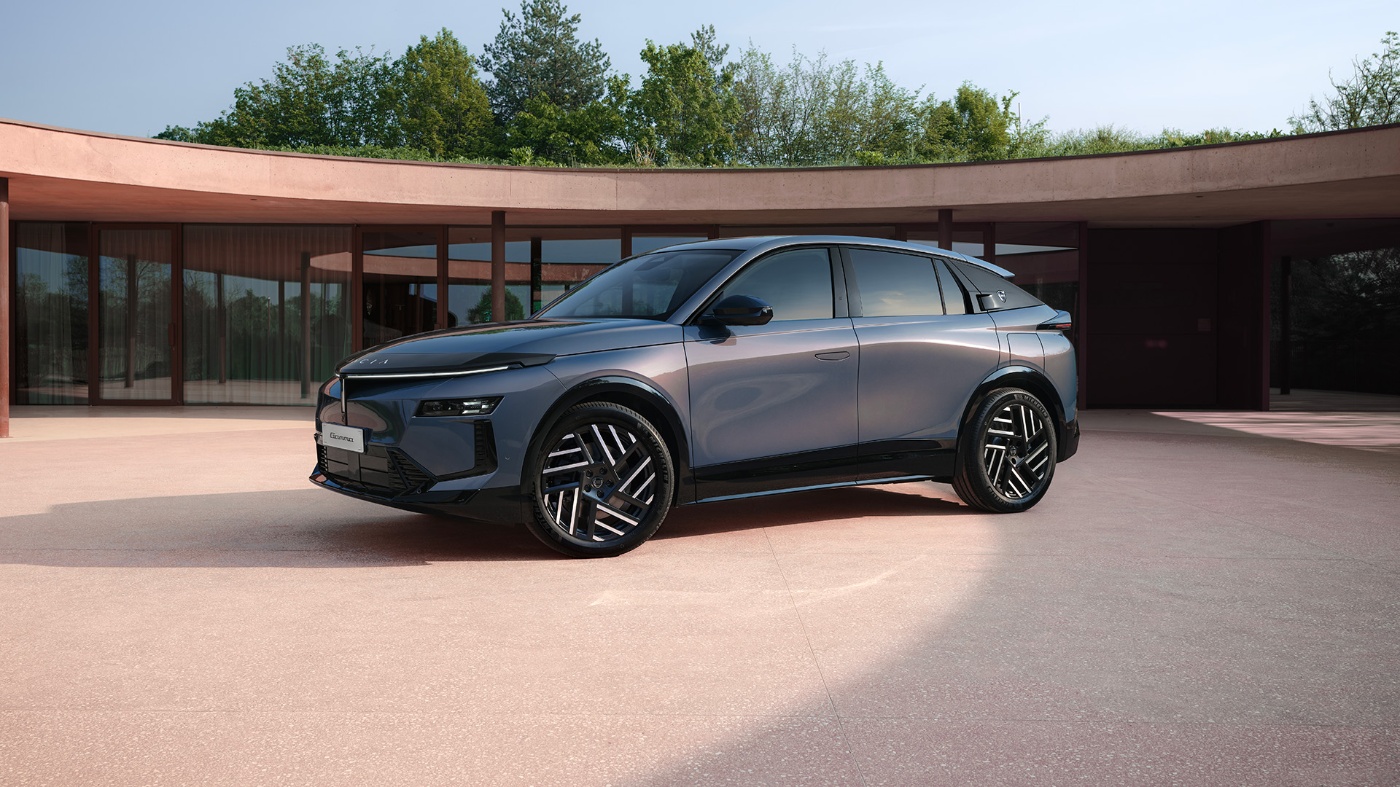 Grauer Lancia SUV steht vor einem modernen Gebäude mit großen Glasfenstern.